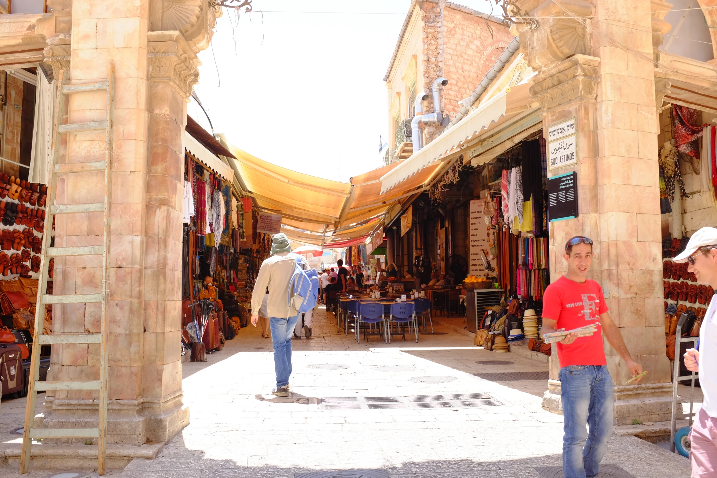 people walking on the side walk of a large market