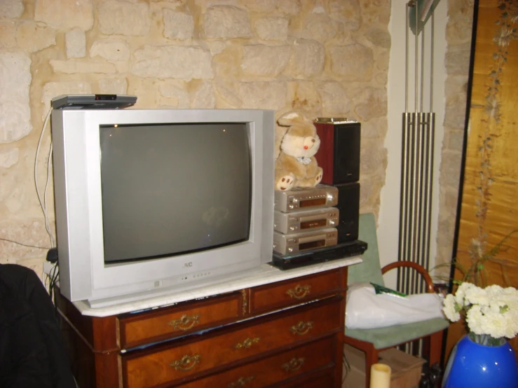 a television sitting on top of a dresser in a bedroom
