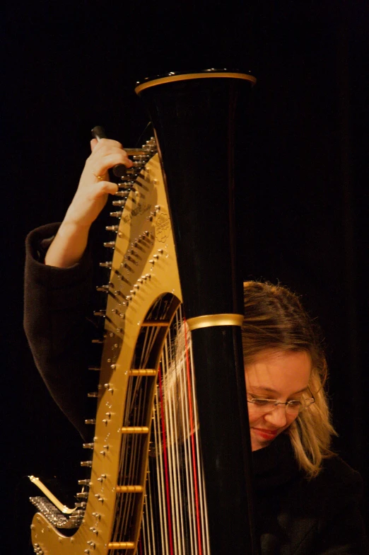 a woman wearing glasses is playing a musical instrument