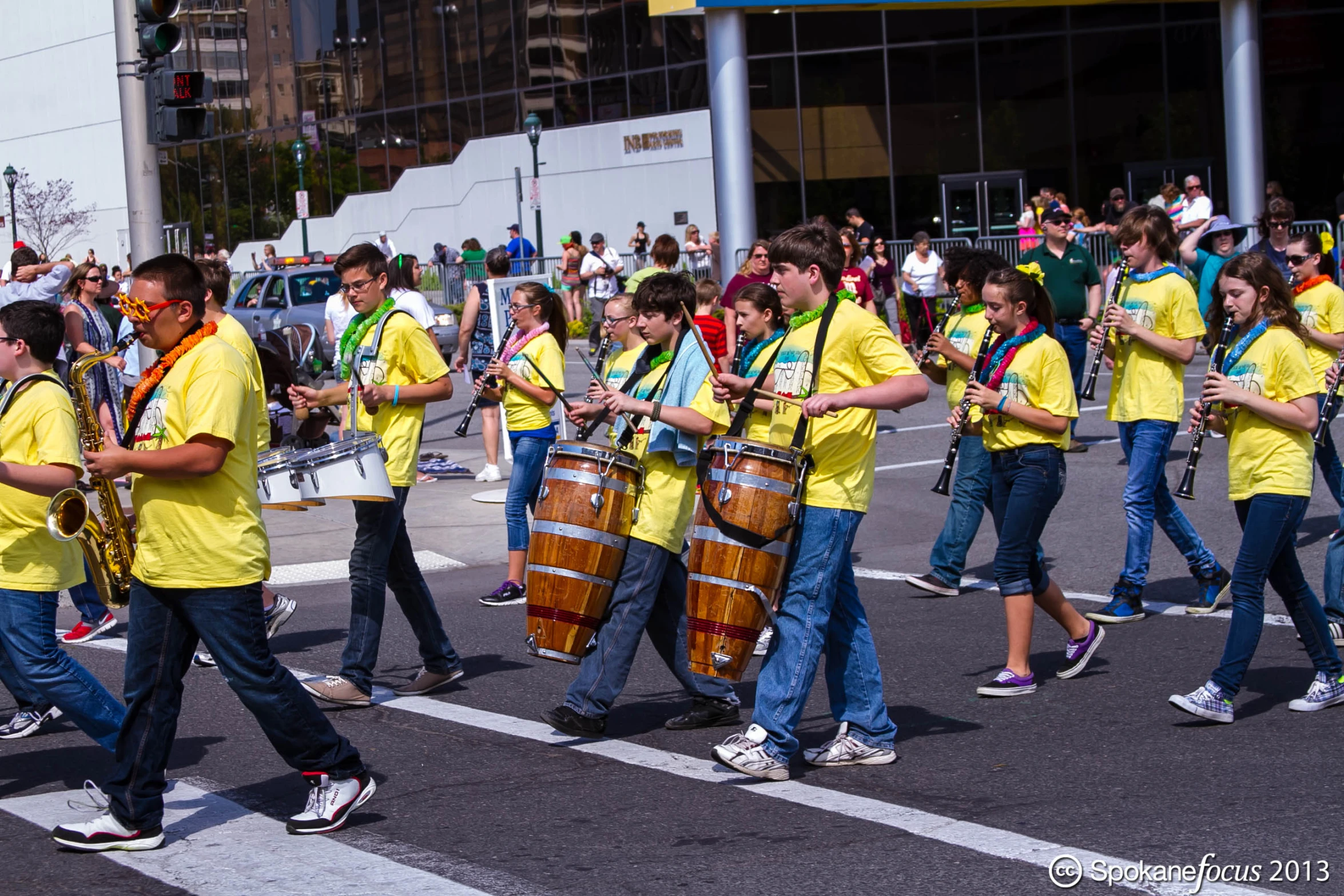 a parade with men and women dressed in yellow, one man in a band