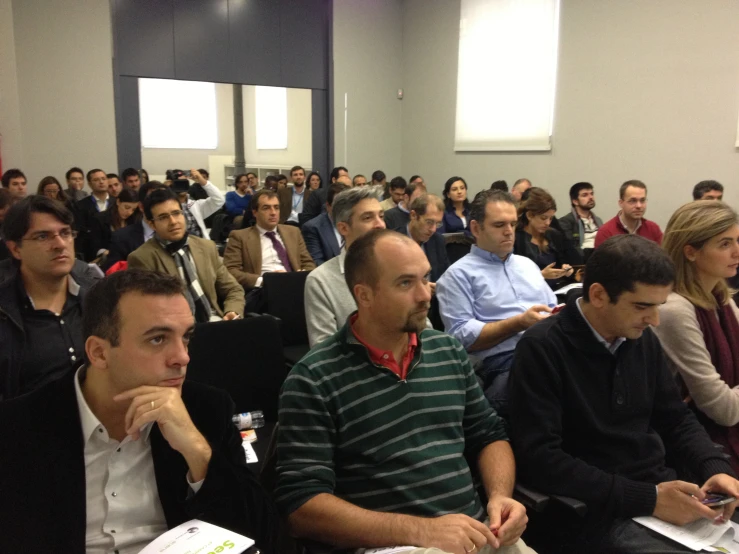 people sitting in rows on their cell phones