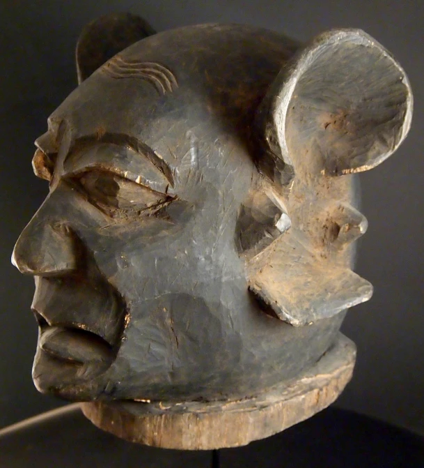 an african mask with long horns sitting on top of a table