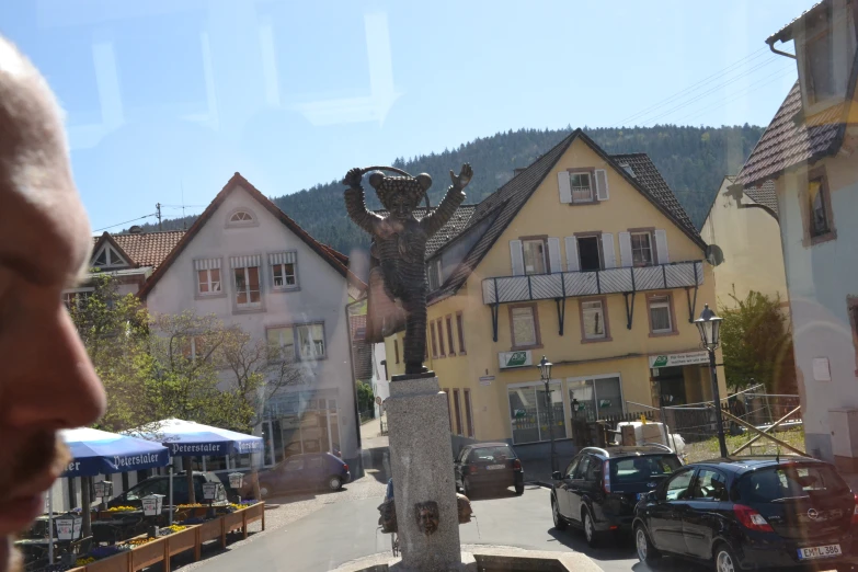 a man looking at a statue in the middle of town