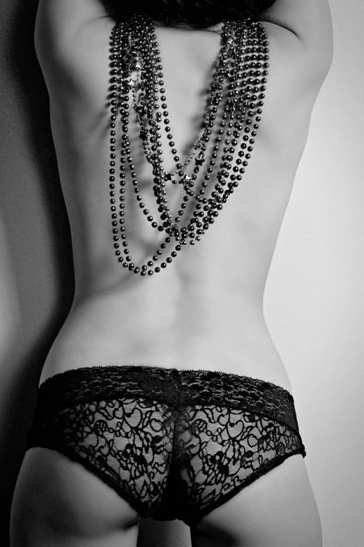 a woman in black underwear has chains attached to her back