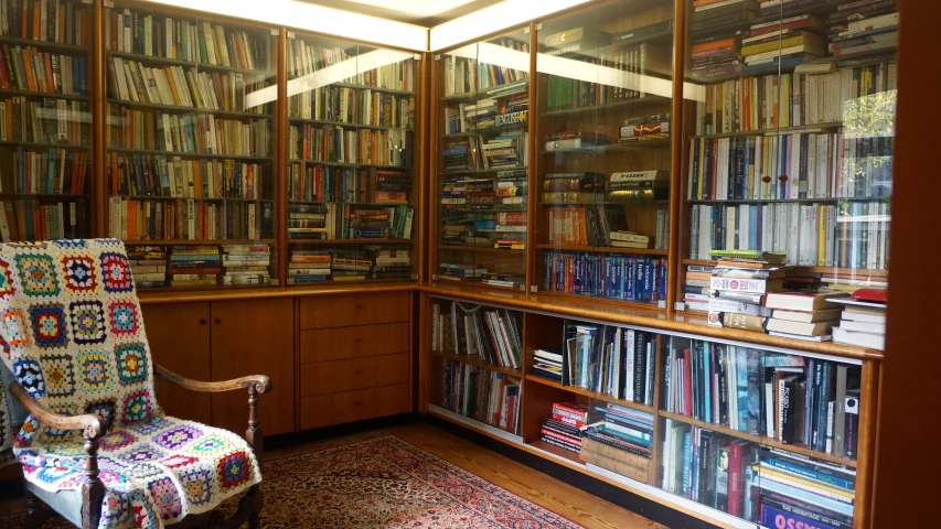 a chair sits in front of a bookcase that contains numerous books