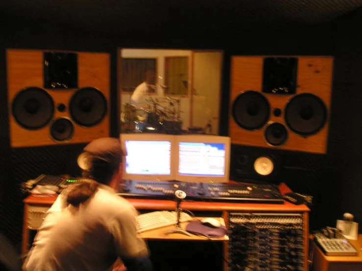 two people are sitting at a table in a music studio