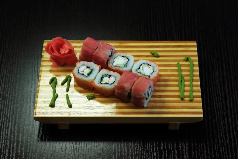 a sushi with two small rolls on a bamboo board
