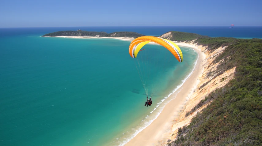 a parasailer that is flying near the ocean