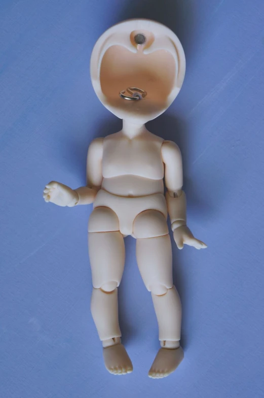 a small plastic doll with a nose ring and two feet, with legs, in the foreground