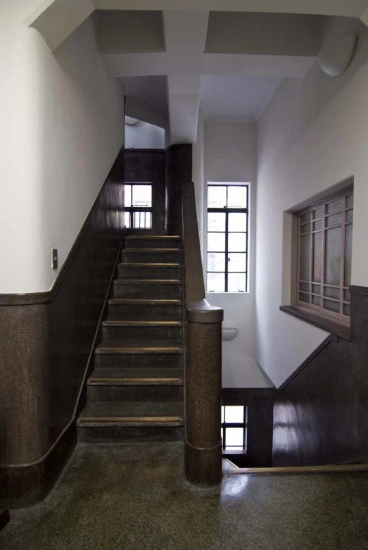 a hallway and stairwell with multiple windows in it