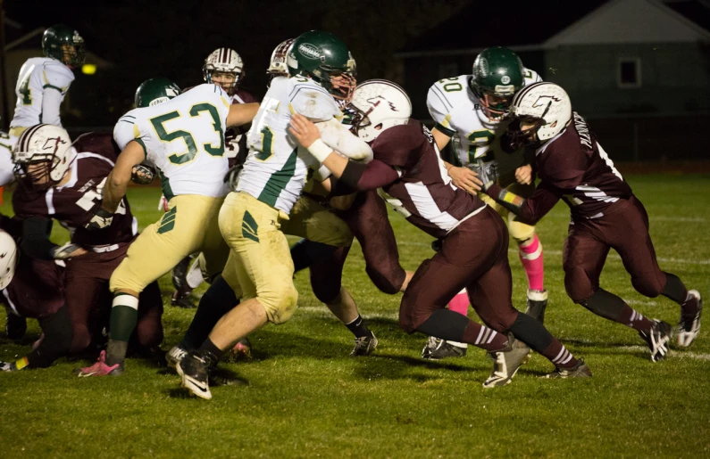 football players on opposing teams compete in a game