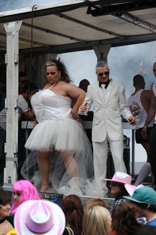 two people dressed in dress clothes, one woman in tutu and one man in suit