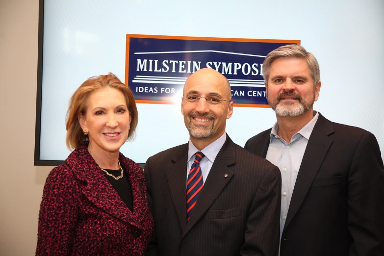 a woman and two men stand beside each other