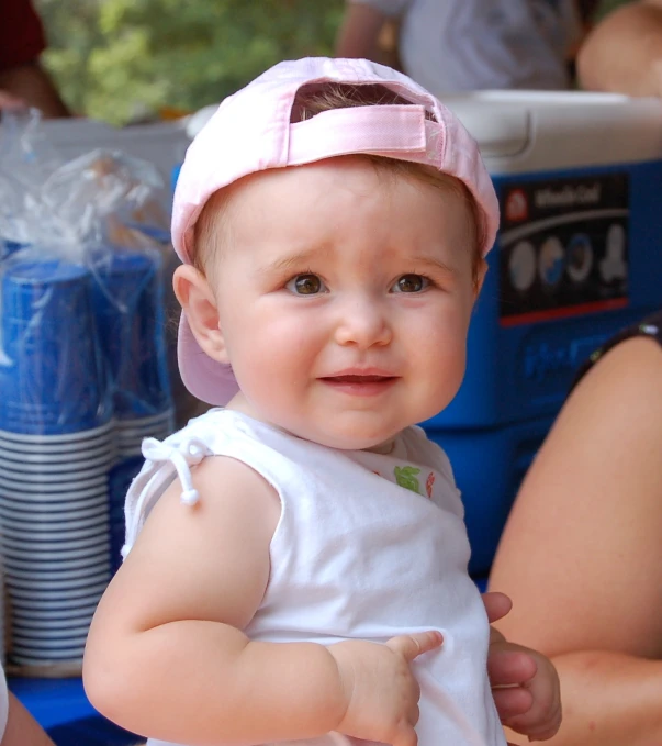 a little girl wearing a hat smiles at the camera