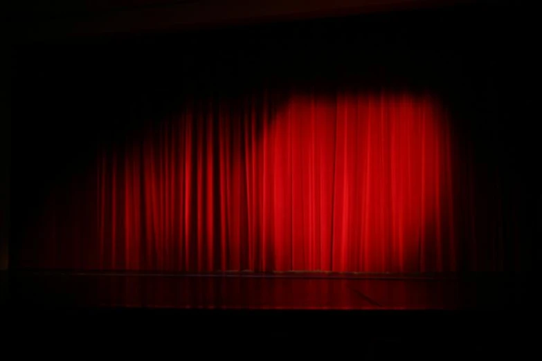 a large, red curtain sits on top of a stage