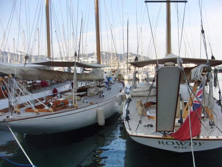 two sailboats are docked together at a harbor