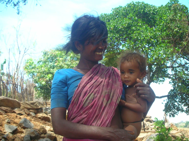 a woman holding her baby in a wrap