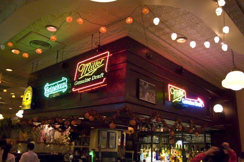 the inside of a pub with some different neon signs on the wall