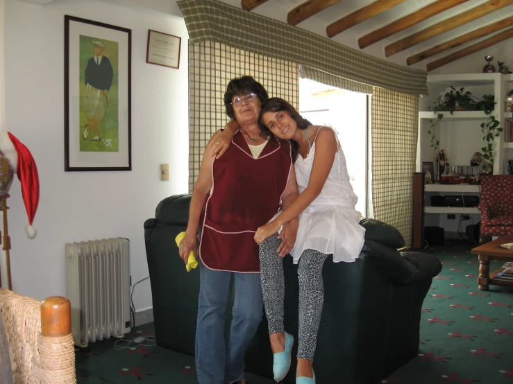 a woman hugging a young woman standing next to a couch