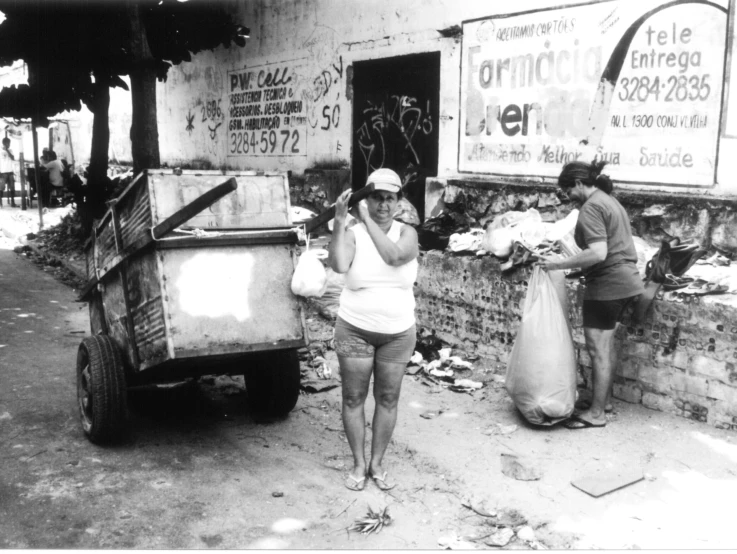 an old black and white picture shows three women collecting garbage