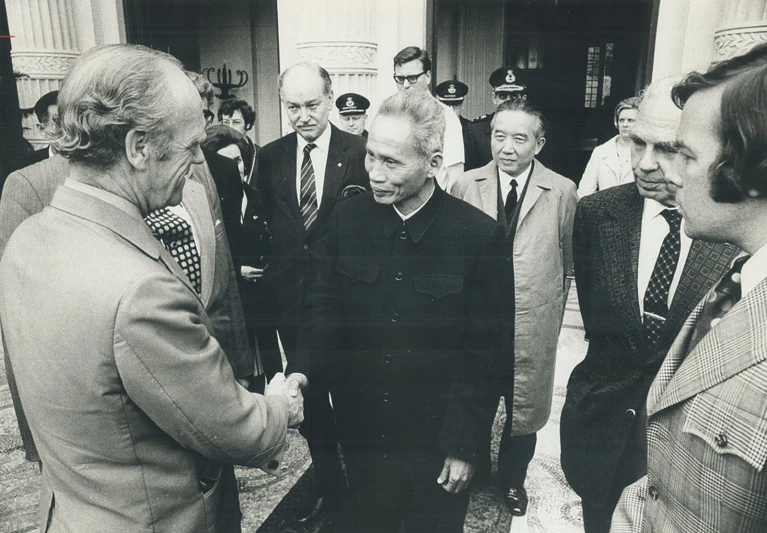 an old po of a man shaking hands with other men