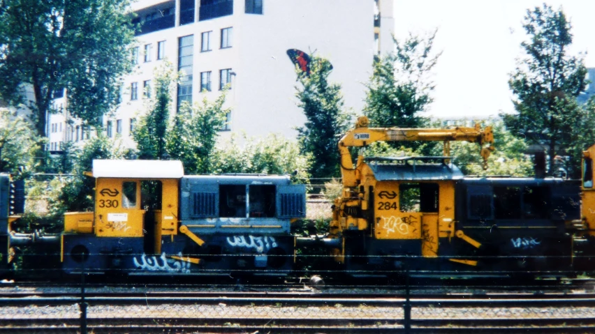 yellow train cars on railroad tracks next to buildings