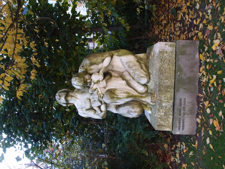 a statue of two s in front of trees