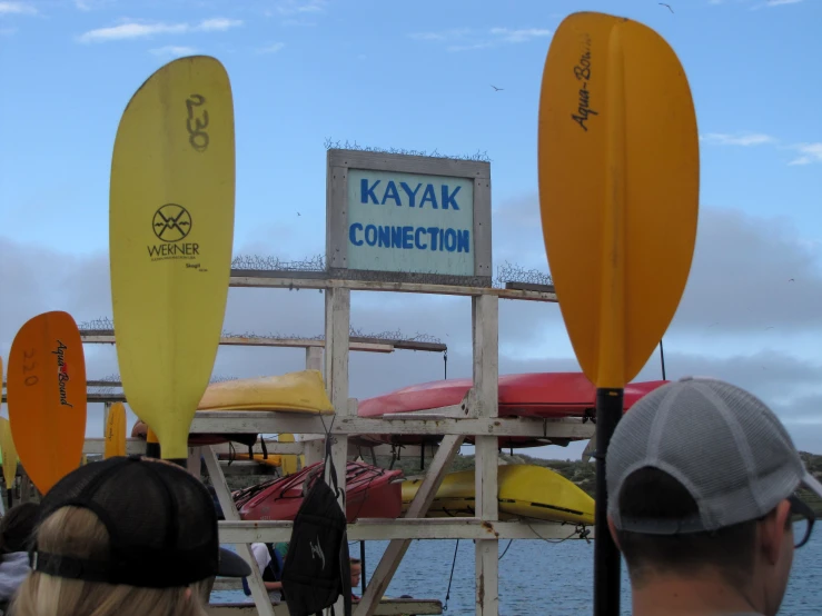 people walking down to some kayaks at a dock