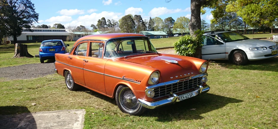 an orange car is parked in the grass