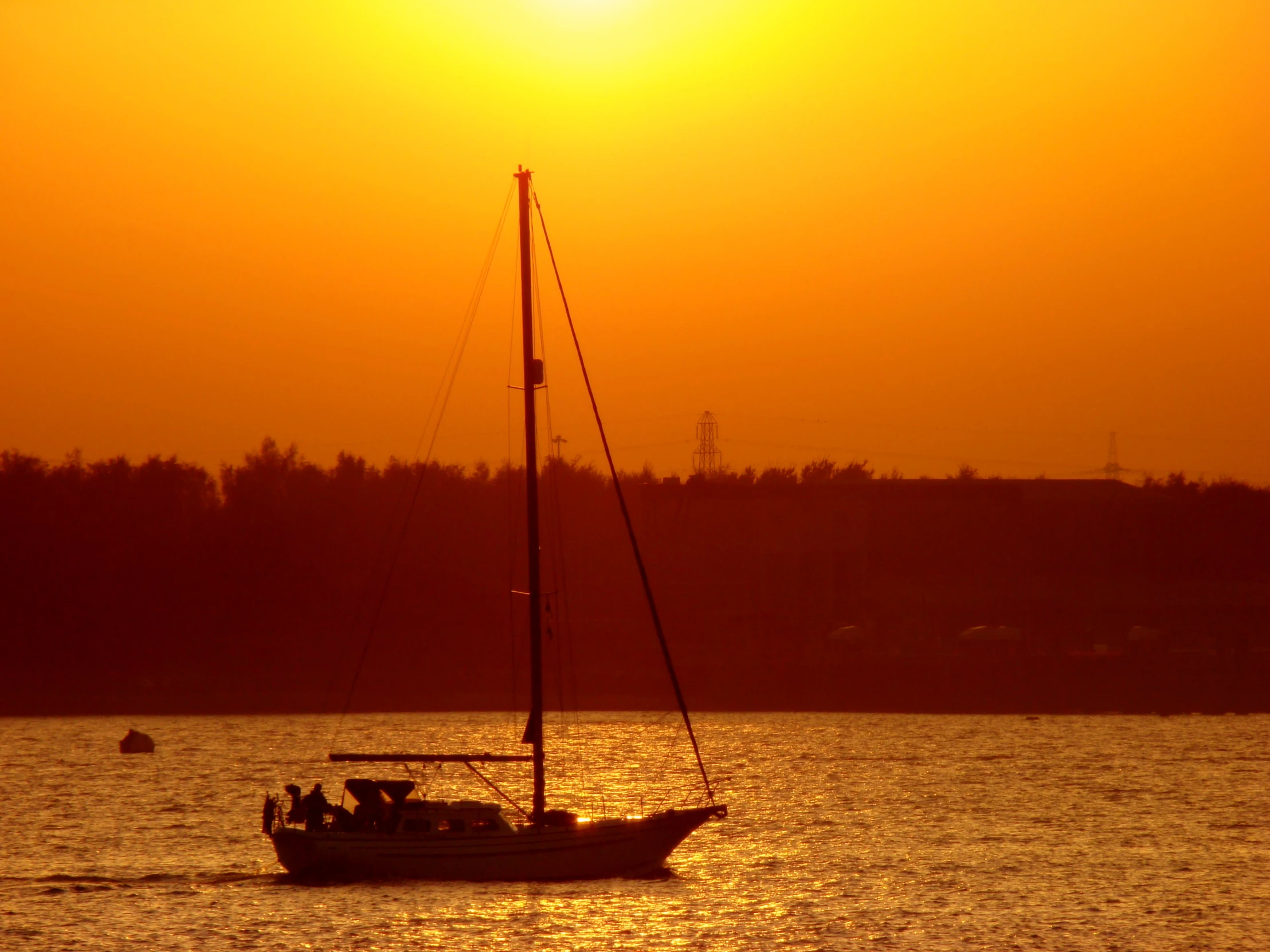 a boat sailing on the water with the sun in the background