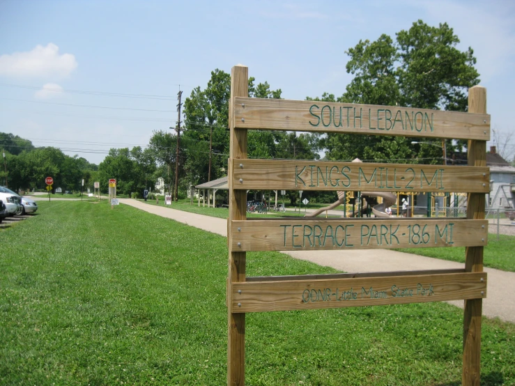 a wooden sign with directions and park like setting