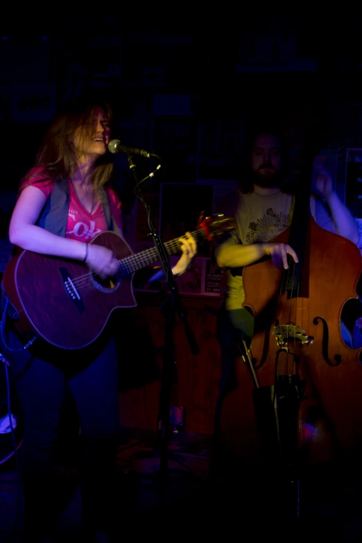 two people are singing into microphones while playing guitars