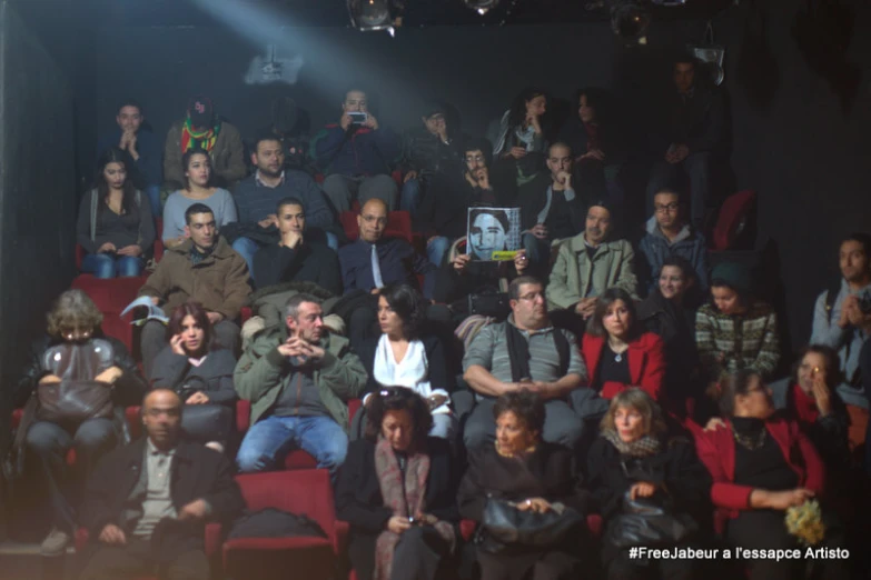 a crowd of people sitting in rows and wearing sunglasses