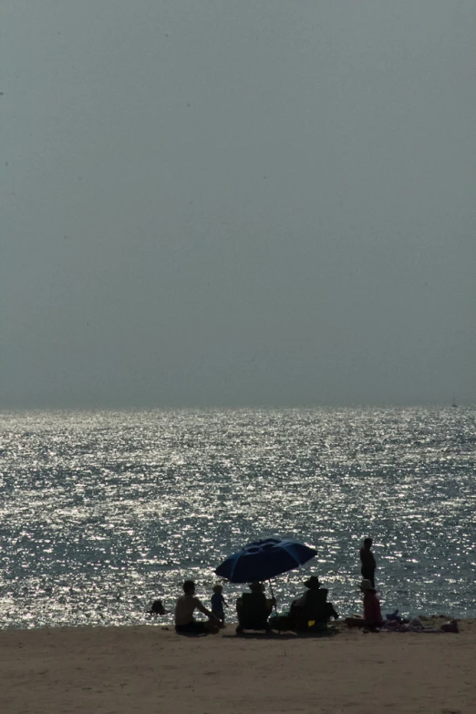 people with umbrellas and chairs are on a beach