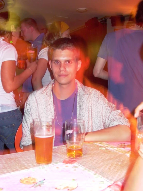 a group of people sitting at a table with beers