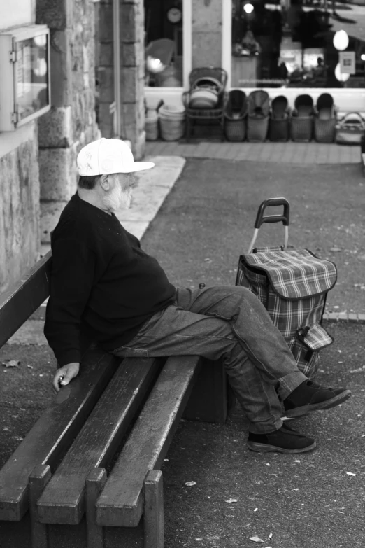 a man sitting on top of a wooden bench