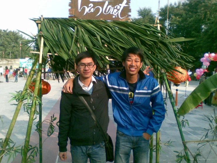 two men pose for the camera at a flower market