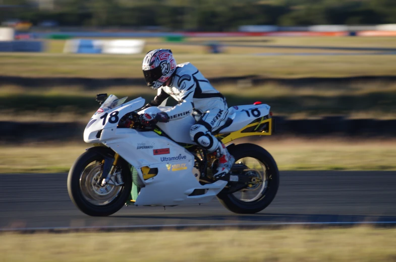 a person on a white motorcycle is racing