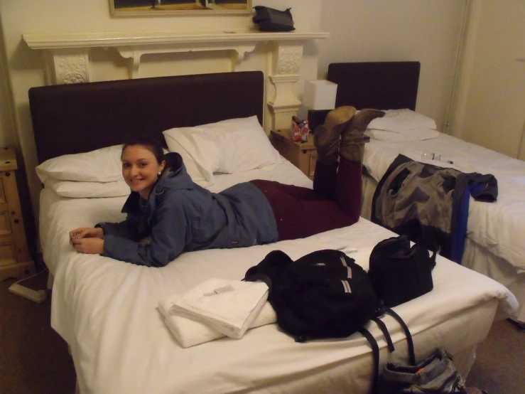 two people in a bedroom with bags and luggage on the bed