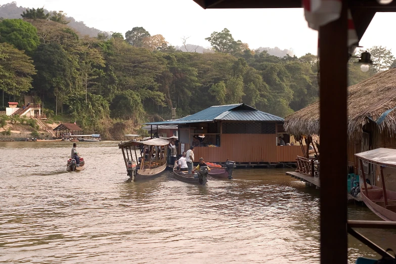 some boats in the water near huts and water