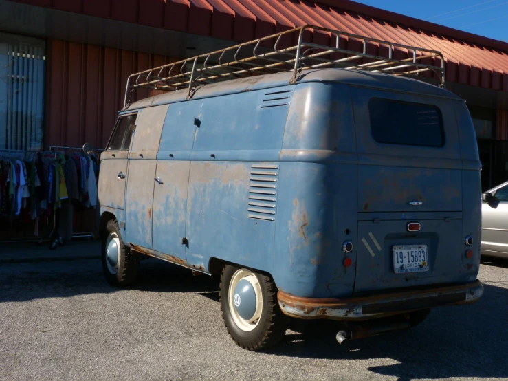 an old blue van parked in front of a building