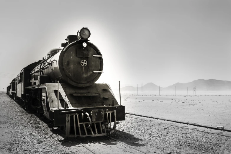 the large train is going down the tracks in the desert