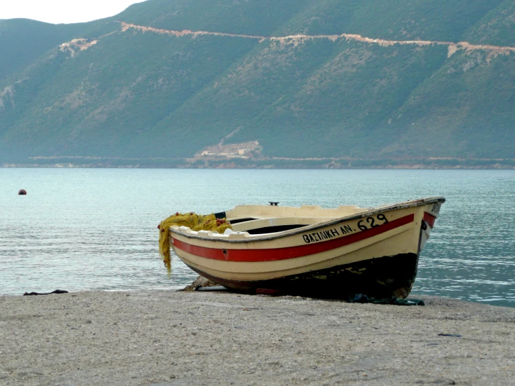 a boat is sitting on the beach near water