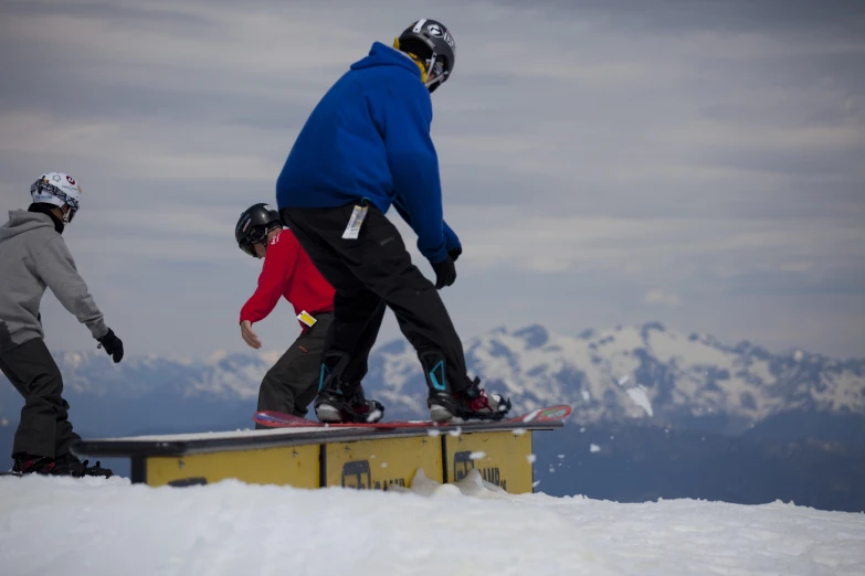 snow boarders in blue jackets on a slope