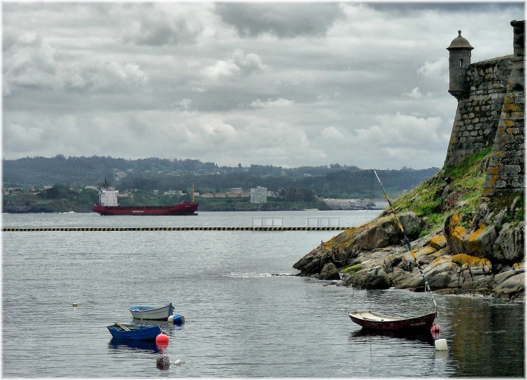 a harbor with boats, rocks and a ship in the water