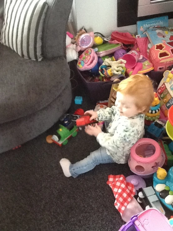 a baby boy plays with lots of toys