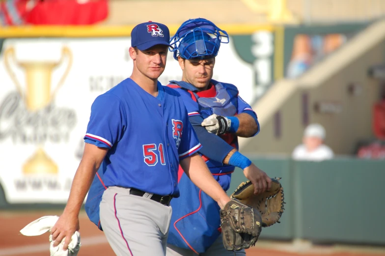 two baseball players each with gloves on standing next to each other