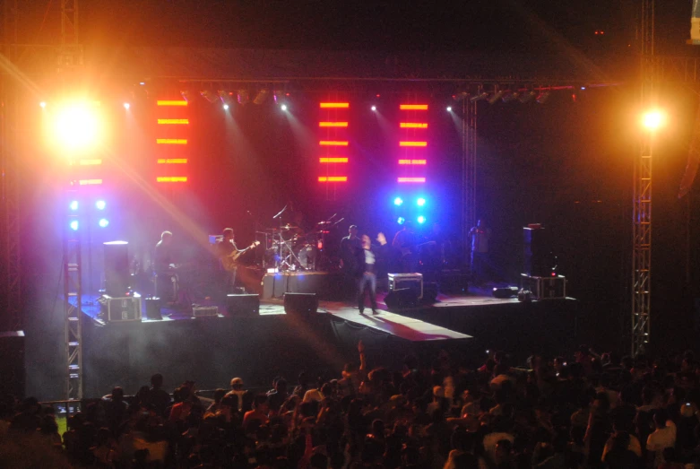 a band playing at an event on a stage with lots of lights