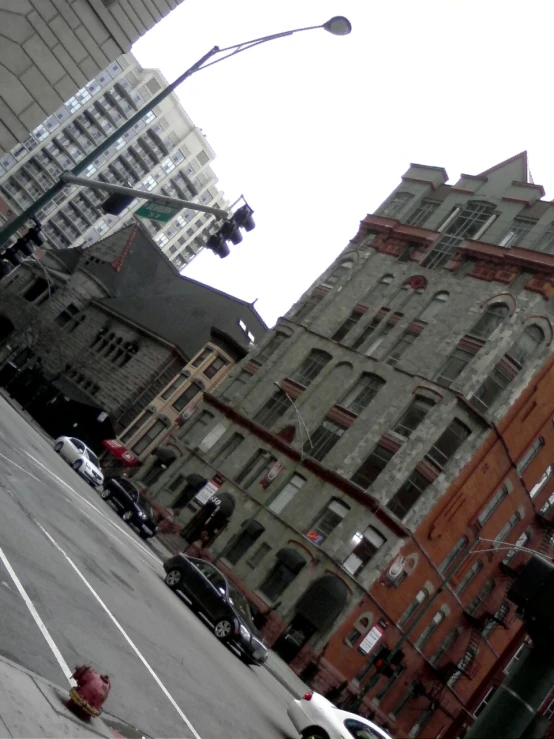 a street with traffic lights, buildings and cars parked on it