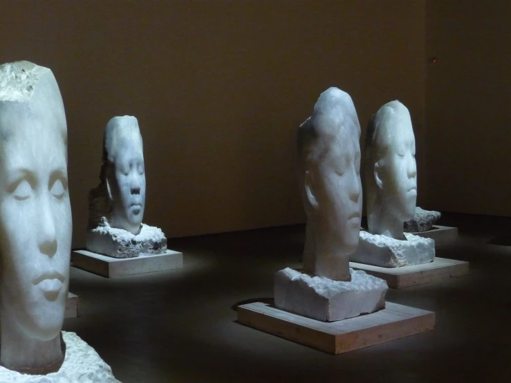 four stone sculptures sitting on display in a room